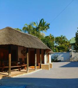 a hut with a straw roof on a beach at Duco self-catering in Nelspruit