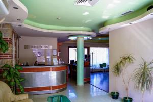 eine Bürolobby mit Theke und Pflanzen in der Unterkunft Dionis Hotel in Warna + 45 Fotos