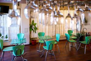 ein Raum mit grünen Stühlen und Tischen in einem Raum in der Unterkunft Dionis Hotel in Warna