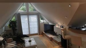 a living room with a couch and a tv at Villa-Mainaue in Maineck