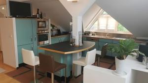 a kitchen with blue cabinets and a table and chairs at Villa-Mainaue in Maineck