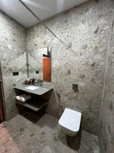 a bathroom with a sink and a toilet and a mirror at Nandan Inn in Dibrugarh