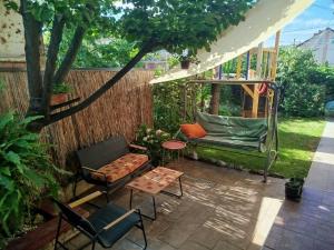 a patio with a gazebo and chairs and a table at Fina Apartman in Leskovac