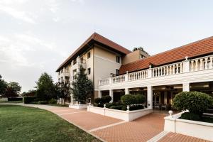 ein großes weißes Gebäude mit rotem Dach in der Unterkunft Arcanum Hotel in Békéscsaba
