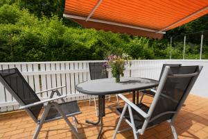a table and chairs on a patio with a white fence at Harzurlaub mit 2 Hunden - FeWo Alte Schule in Sankt Andreasberg in Sankt Andreasberg