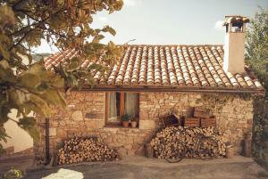 una casa de piedra con una pila de leña y una bicicleta en La Lagunilla, en Laguna del Marquesado