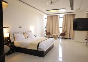 a hotel room with a bed and a television at Hotel Capital in Noida
