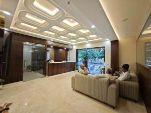 a group of people sitting on a couch in a lobby at Hotel Kaashika in Varanasi
