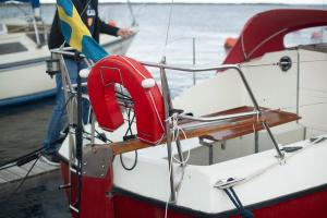 a red and white boat with a flag on it at Jahta Engures ostā in Engure