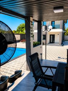 a patio with a table and a chair next to a pool at Grey House in Bucharest