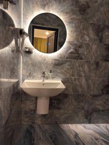 a bathroom with a sink and a mirror at Mzeonas Apartment in Kobuleti +54 photos