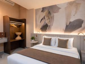 a bedroom with a large bed with a painting above it at เดย์ อินน์ บาย วินด์แฮม ระยอง อู่ตะเภา in Rayong +115 photos