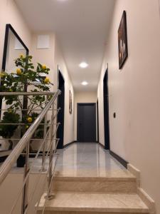 a hallway with stairs with a plant and a door at Mzeonas Apartment in Kobuleti