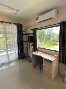 a room with a desk with a large window and a computer at Malina Guesthouse in Ko Phangan