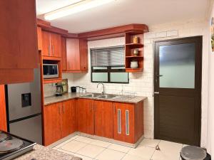 a small kitchen with wooden cabinets and a sink at Local Roots in Pinetown