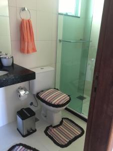 uma casa de banho com um WC e uma cabina de duche em vidro. em Apartamento em Arraial do Cabo em Arraial do Cabo