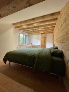 a bedroom with a green bed in a room at Chalet Les Balcons du Risoux in Bellefontaine