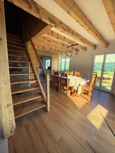 a dining room and living room with a staircase in a house at Chalet Les Balcons du Risoux in Bellefontaine