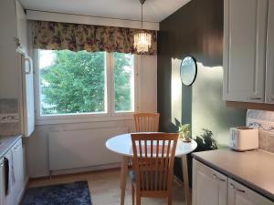 a kitchen with a table and two chairs and a window at Kaksio lähellä keskustaa in Iisalmi