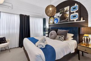 a bedroom with a large bed with a blue and white comforter at Eleda House Hunter Valley Escape in Cessnock