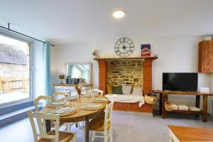 a dining room with a table and a bedroom at Chez Manie Et Mablot in Créances