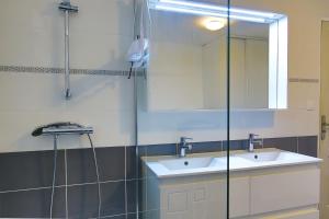 a bathroom with a sink and a mirror at Chez Manie Et Mablot in Créances +23 photos