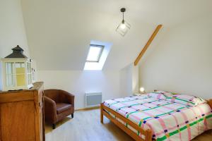 a bedroom with a bed and a chair in it at Chez Manie Et Mablot in Créances