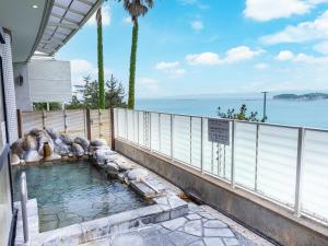 a swimming pool in front of a house at The Gran Resort Elegante Shirahama in Shirahama