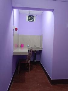 a purple bathroom with a sink and a chair at Pranoti guest house in Dibrugarh