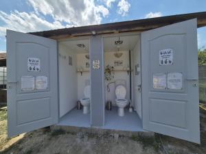 a bathroom with two toilets and two doors at The Nest Room in Bontida
