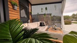 a patio with a couch and a table and a fence at Ausblick Sunce i More Mobilehome in Pirovac +25 photos