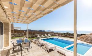 a villa with a swimming pool and a patio at Villa Lefkopetra in Triopetra
