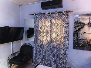 ein Zimmer mit einem Zebramuster-Vorhang an der Wand in der Unterkunft RÉSIDENCE PRIVÉE 1 Chambre avec Salon, Cuisine Équipée, Climatisation, Wifi et Cour Individuelle in Ouagadougou