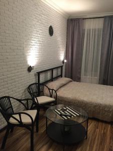a bedroom with a bed and two chairs and a table at Guest House "Nevsky 6" in Saint Petersburg