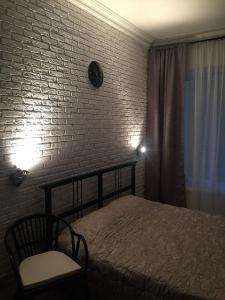 a bedroom with a bed and a brick wall at Guest House "Nevsky 6" in Saint Petersburg