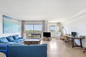 a living room with blue couches and a table at Port Pals B202 in Pals