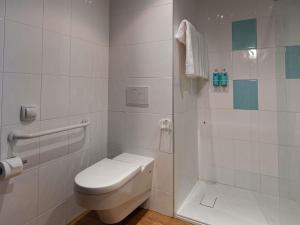 a white bathroom with a toilet and a shower at Novotel Caserta Sud in Caserta +122 photos