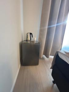 a room with a coffee maker on a dresser next to a window at Osterøy Minihotell in Lonevåg