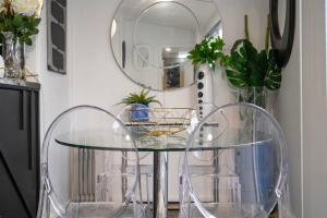 a glass table with two chairs and a mirror at Eleda House Hunter Valley in Cessnock