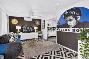 a living room with a large mural of a man at Eleda House Hunter Valley in Cessnock