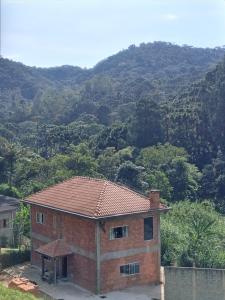 a brick house with a mountain in the background at Pousada Casa Terra de Pinheiros in Santo Antônio do Pinhal +30 photos
