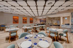 ein Restaurant mit Tischen und Stühlen und einer Bar in der Unterkunft Kingsgate Hotel Clock Tower in Dubai