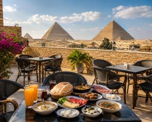 a table with food on it with the pyramids in the background at Oyal Scarab Pyramids View in Cairo
