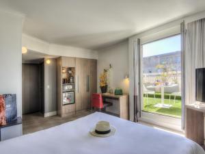 a room with a bed and a large window at Novotel Marseille Centre Prado Vélodrome in Marseille
