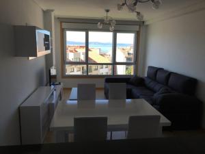 sala de estar con sofá y mesa con sillas en Residencial La Florida - Sanxenxo, en Sanxenxo