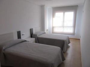 a hotel room with two beds and a window at Residencial La Florida - Sanxenxo in Sanxenxo