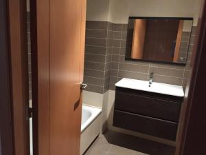 a bathroom with a sink and a mirror and a tub at Residencial La Florida - Sanxenxo in Sanxenxo