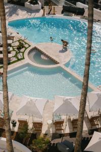 a large swimming pool with tables and umbrellas at President Hotel in Cape Town