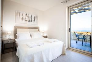 a white bedroom with a bed and a large window at Villa Lefkopetra in Triopetra +25 photos