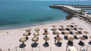 a group of chairs with umbrellas on a beach at Студиа При Американеца in Pomorie